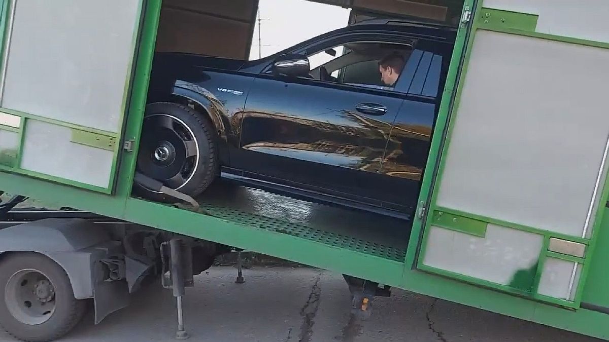 Погрузка внедорожника Mercedes в крытый автовоз